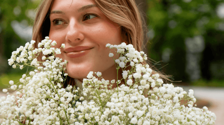 Woman Holding Bouquet of Flowers and Smiling Happily